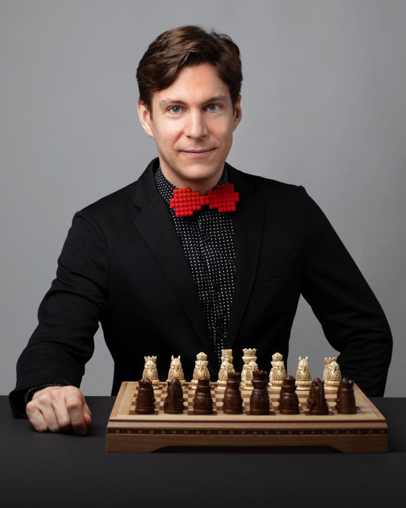 ROCO Guest Composer Maxime Goulet posing with a chess board ahead of the premiere of Checkmate