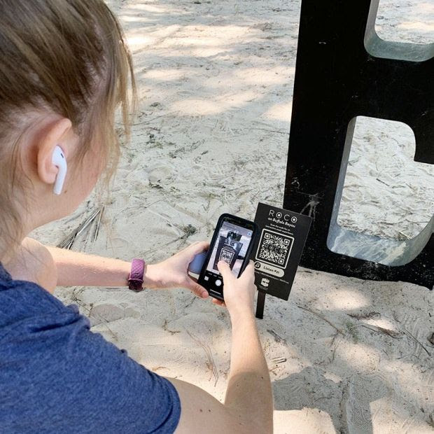 Girl scanning ROCO on the Go QR code at Buffalo Bayou Trail